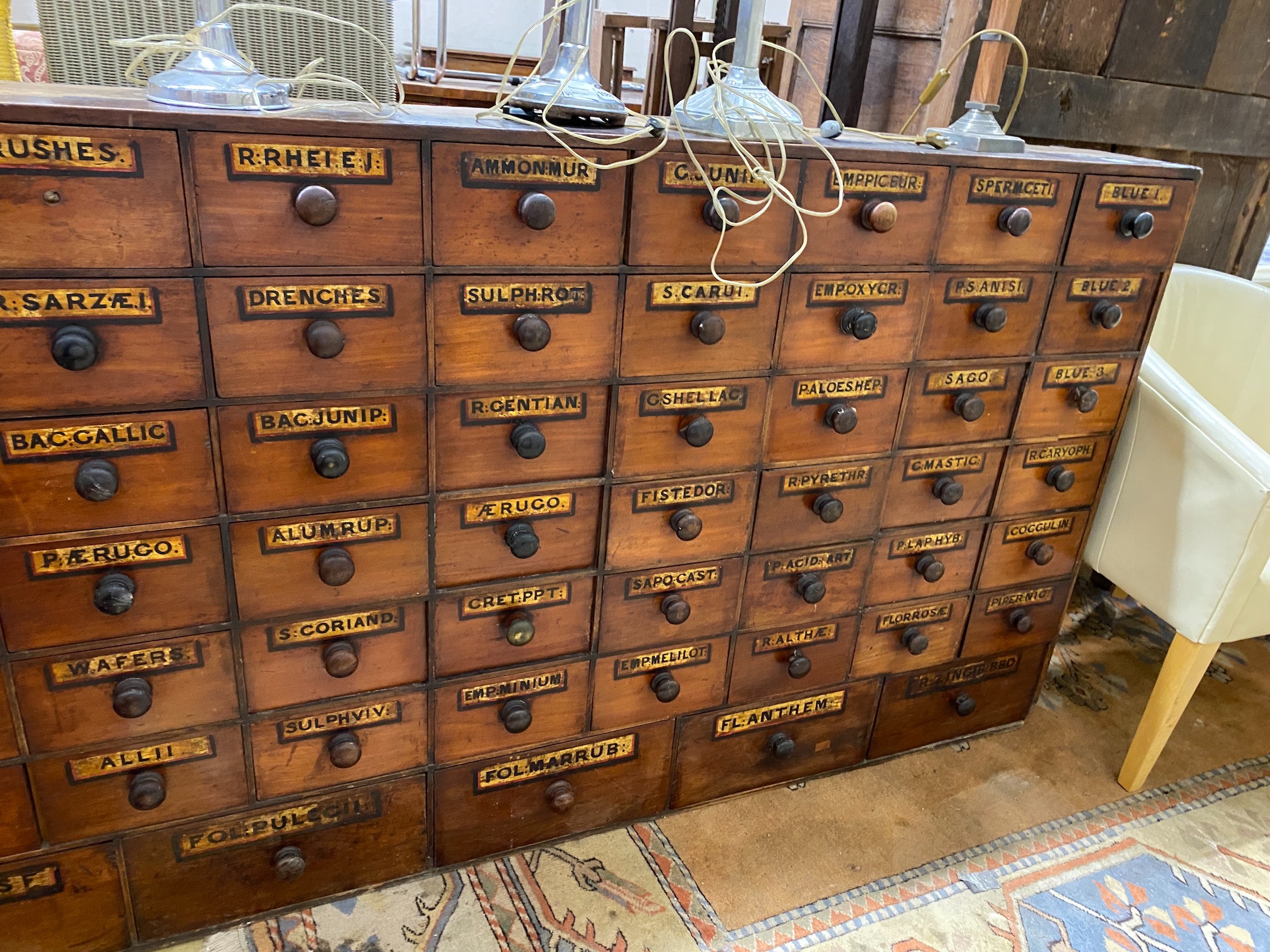 A 19th century mahogany and pine 66 drawer apothecary chest with turned wood handles and some later painted detail, length 227cm, depth 20cm, height 102cm